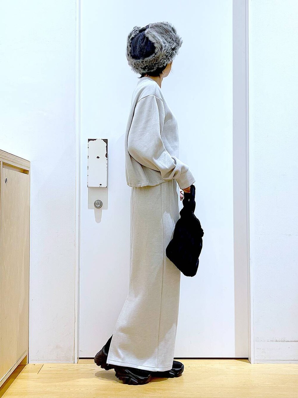 ブラック系のブーツ、ブラック系のショルダーバッグ、ベージュ系のスウェットを着用したレディースの冬コーディネートの4枚目の写真