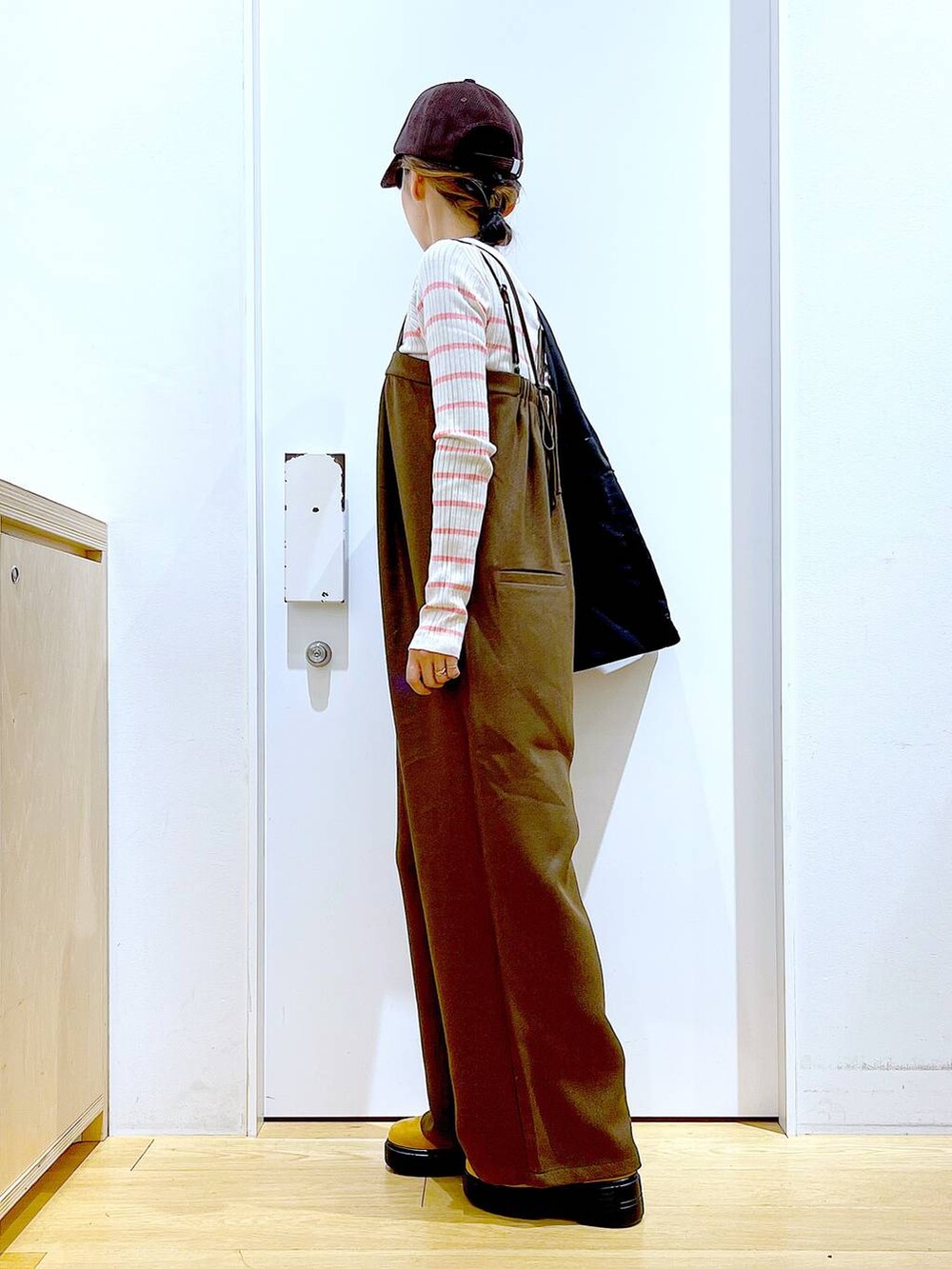 ピンク系のニット/セーター、ブラック系のショルダーバッグ、ベージュ系のブーツを着用したレディースの冬コーディネートの3枚目の写真