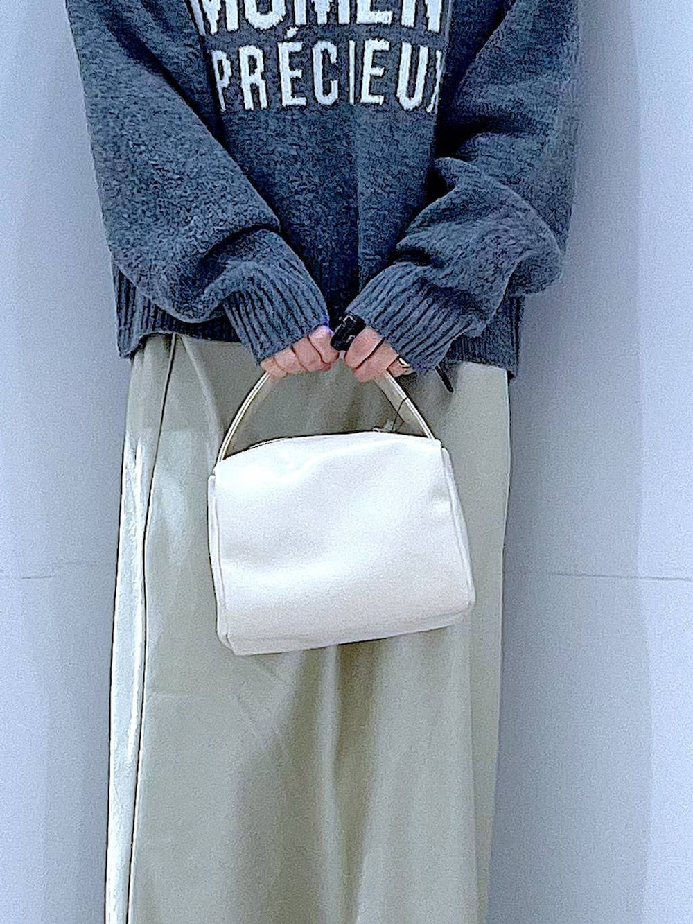 ブラック系のブーツ、グレー系のニット/セーター、ホワイト系のショルダーバッグを着用したレディースの冬コーディネートの9枚目の写真