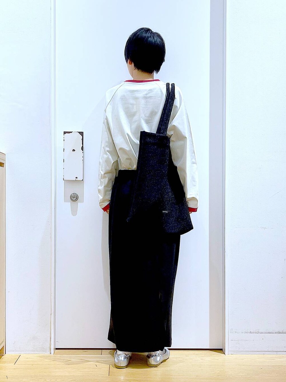 ブラック系のトートバッグ、シルバー系のパンプス、ブラック系のスカートを着用したレディースの春コーディネートの5枚目の写真