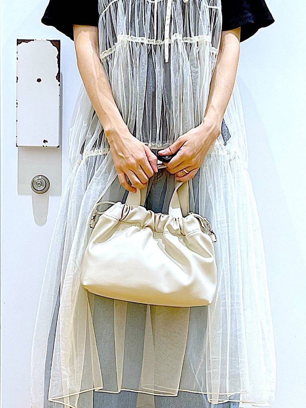 ブルー系のデニムパンツ、ホワイト系のショルダーバッグ、ブラック系のTシャツ/カットソーを着用したレディースの夏コーディネートの9枚目の写真