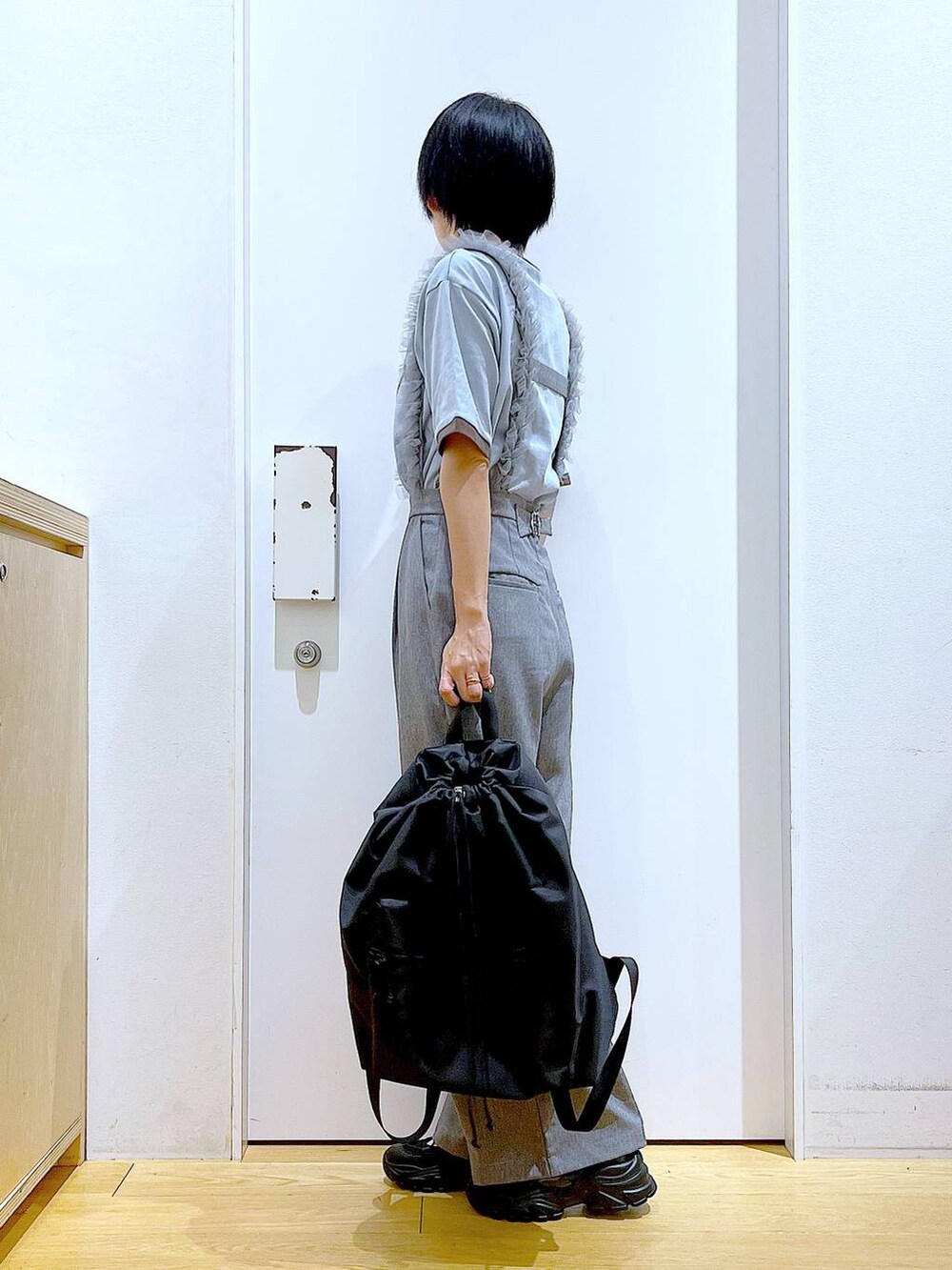 ブラック系のスニーカー、ブラック系のバックパック/リュック、グレー系のその他パンツを着用したレディースの春コーディネートの3枚目の写真