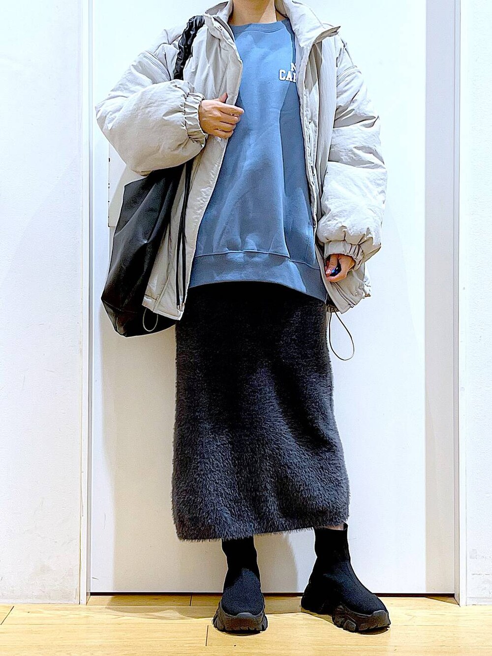 ブラック系のブーツ、ブルー系のスウェット、ブラック系のショルダーバッグを着用したレディースの冬コーディネートの6枚目の写真