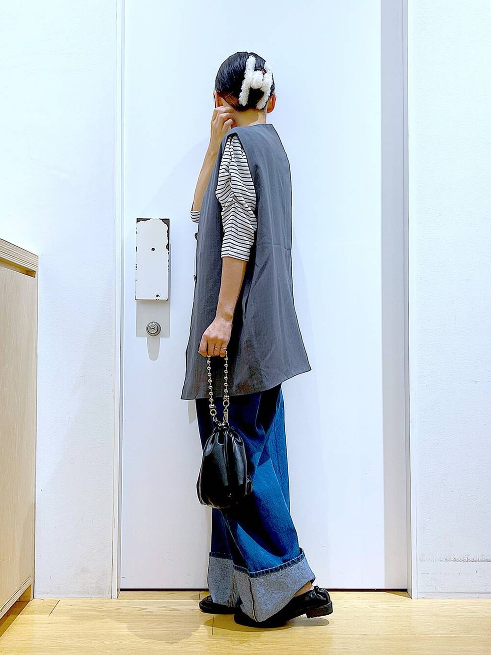 ブラック系のショルダーバッグ、ブラック系のローファー、グレー系のベストを着用したレディースの秋コーディネートの3枚目の写真