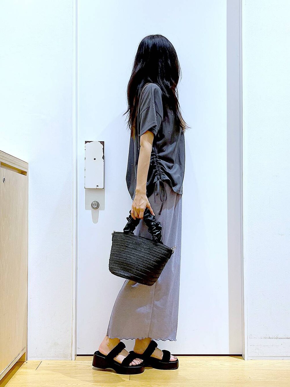 パープル系のスカート、ブラック系のショルダーバッグ、ブラック系のサンダルを着用したレディースの夏コーディネートの4枚目の写真