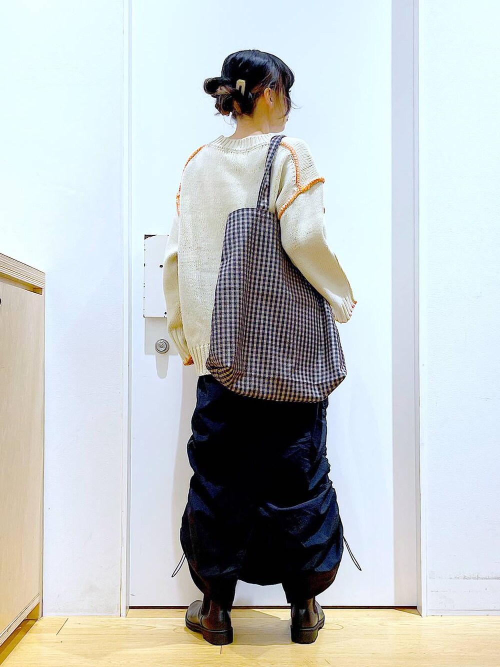 ブラック系のブーツ、その他のトートバッグ、ブラック系のスカートを着用したレディースの冬コーディネートの5枚目の写真