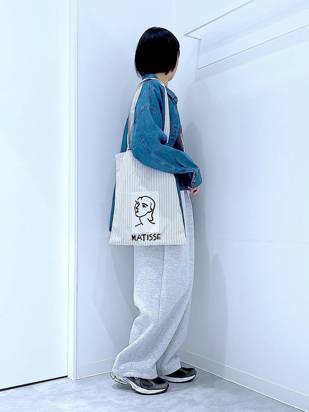 ブルー系のシャツ/ブラウス、ブラウン系のトートバッグ、グレー系のTシャツ/カットソーを着用したレディースの秋コーディネートの4枚目の写真