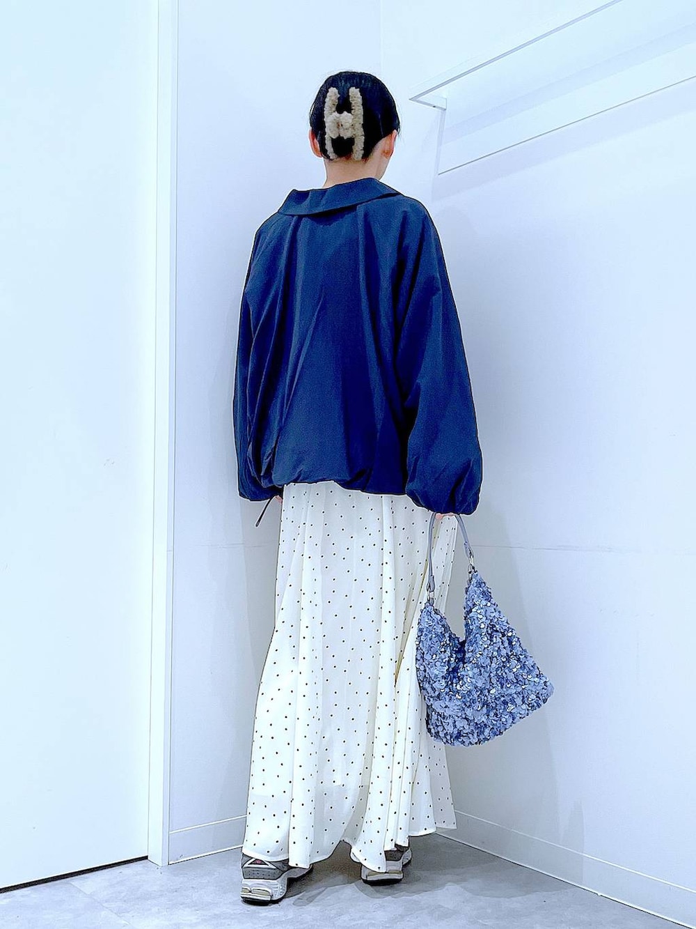 ブルー系のブルゾン、ブラック系のTシャツ/カットソー、ホワイト系のスカートを着用したレディースの春コーディネートの5枚目の写真