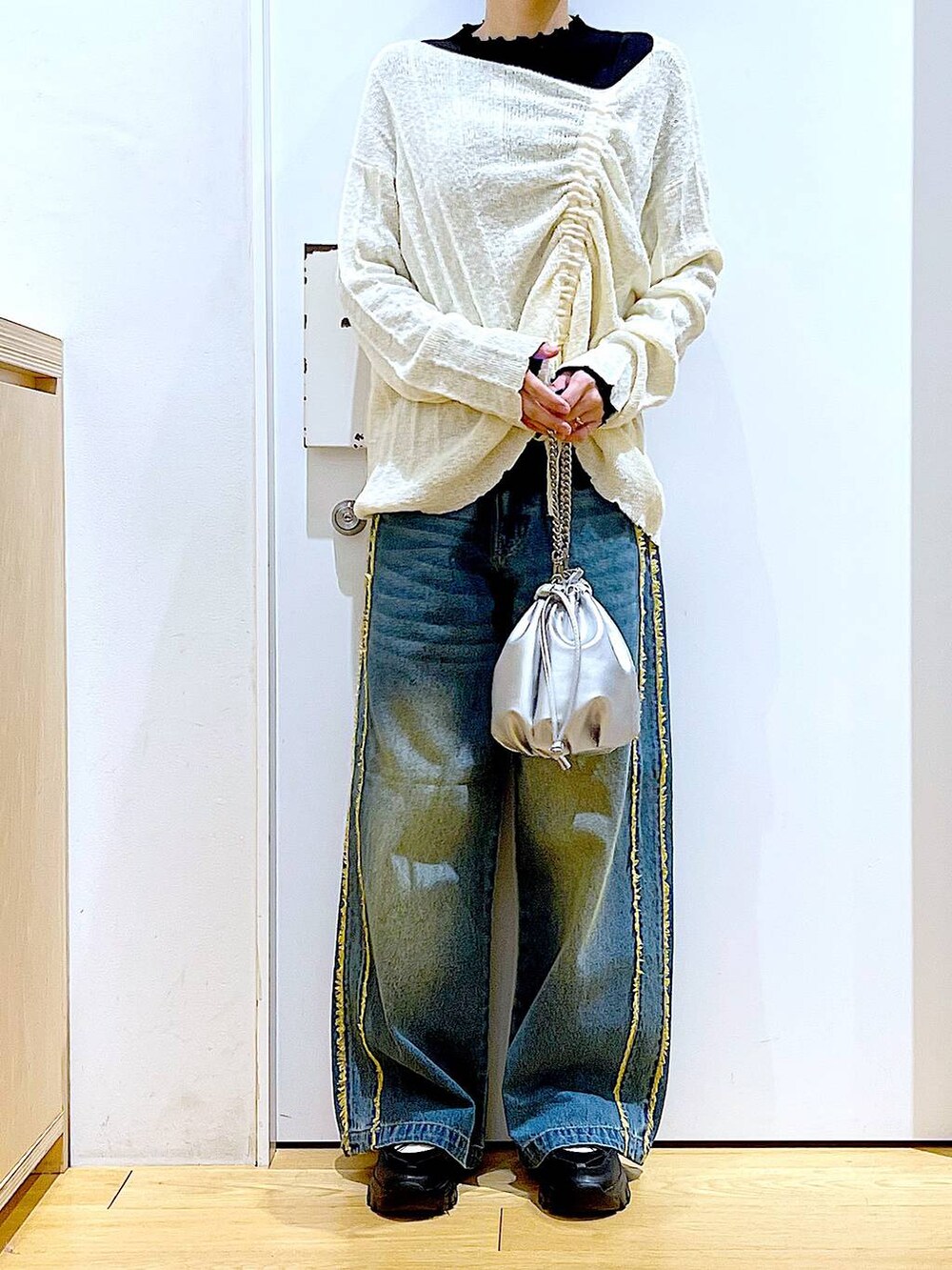 ブラック系のTシャツ/カットソー、シルバー系のショルダーバッグ、ブラック系のスニーカーを着用したレディースの春コーディネートの6枚目の写真