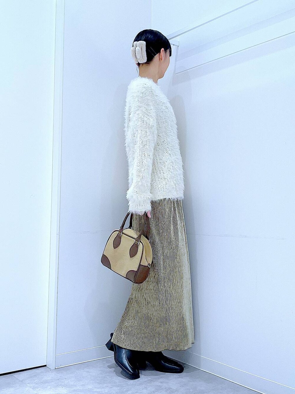 ベージュ系のハンドバッグ、ブラック系のブーツ、ベージュ系のニット/セーターを着用したレディースの冬コーディネートの4枚目の写真