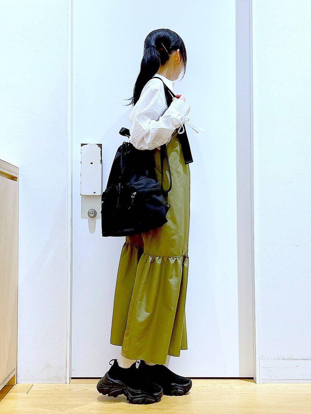 ブラック系のショルダーバッグ、グリーン系のワンピース、ホワイト系のシャツ/ブラウスを着用したレディースの春コーディネートの4枚目の写真