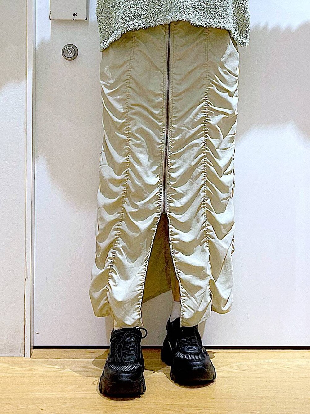 ベージュ系のスカート、ブラック系のボストンバッグ、ブラック系のTシャツ/カットソーを着用したレディースの春コーディネートの8枚目の写真