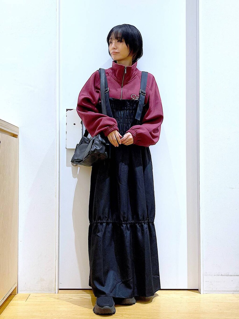 ブラック系のブーツ、ブラック系のショルダーバッグ、ブラック系のワンピースを着用したレディースの秋コーディネートの2枚目の写真