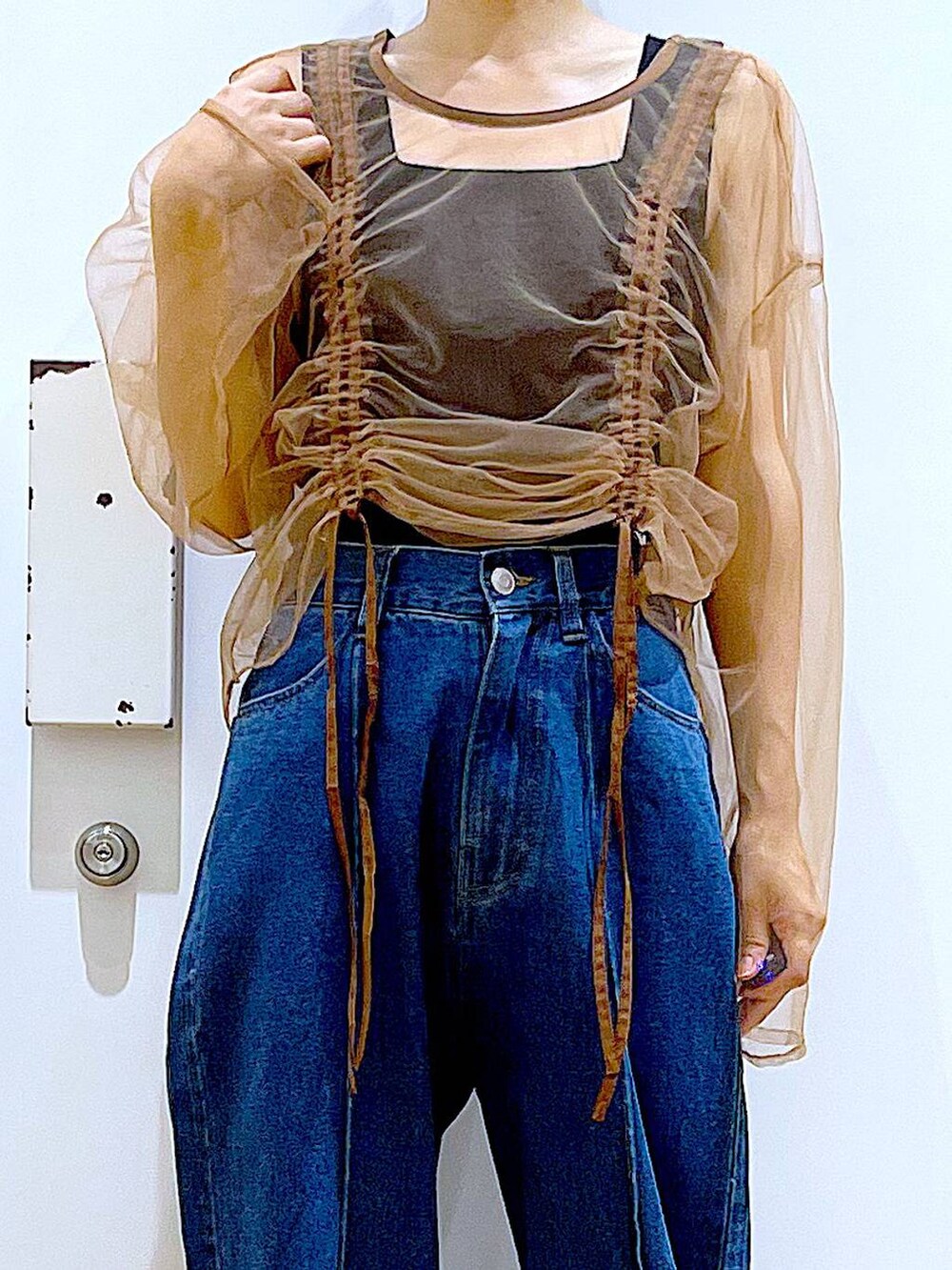 イエロー系のハンドバッグ、シルバー系のローファー、ブルー系のデニムパンツを着用したレディースの秋コーディネートの7枚目の写真