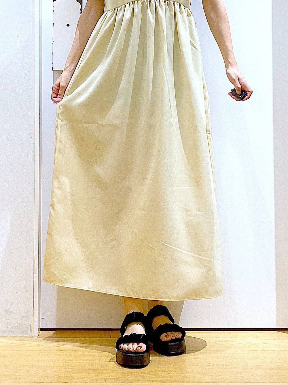 ブラック系のサンダル、イエロー系のワンピース、ブラック系のカーディガン/ボレロを着用したレディースの夏コーディネートの8枚目の写真