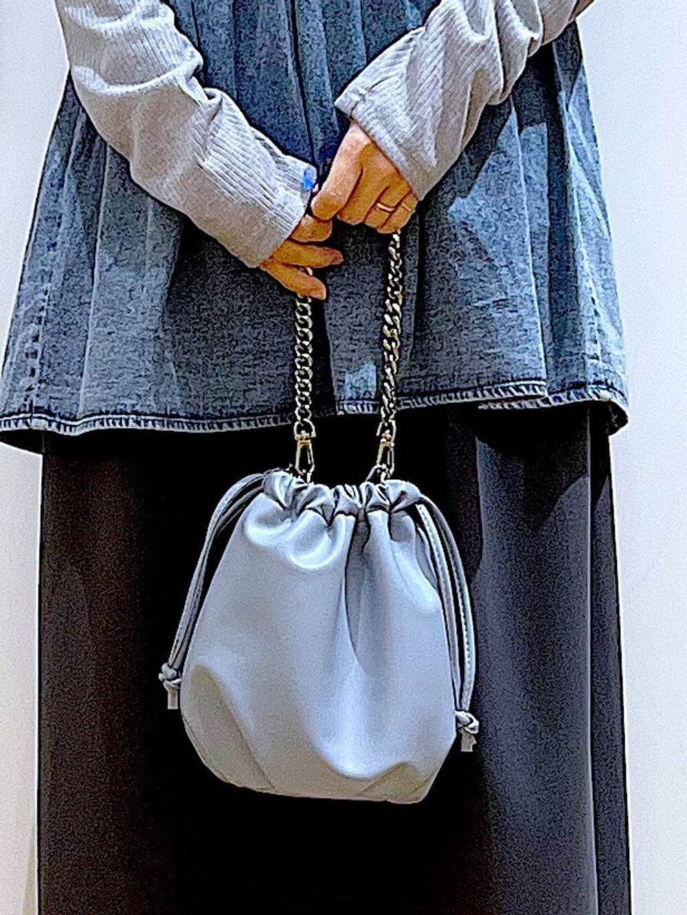 ブルー系のショルダーバッグ、ブラック系のパンプス、ブルー系のその他トップスを着用したレディースの春コーディネートの9枚目の写真