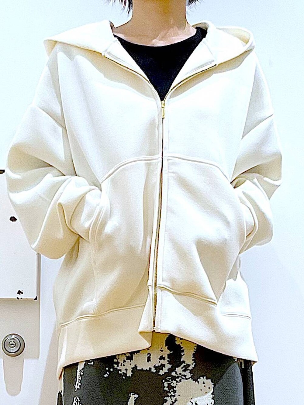 グレー系のスカート、ベージュ系のトートバッグ、ブラック系のブーツを着用したレディースの秋コーディネートの7枚目の写真