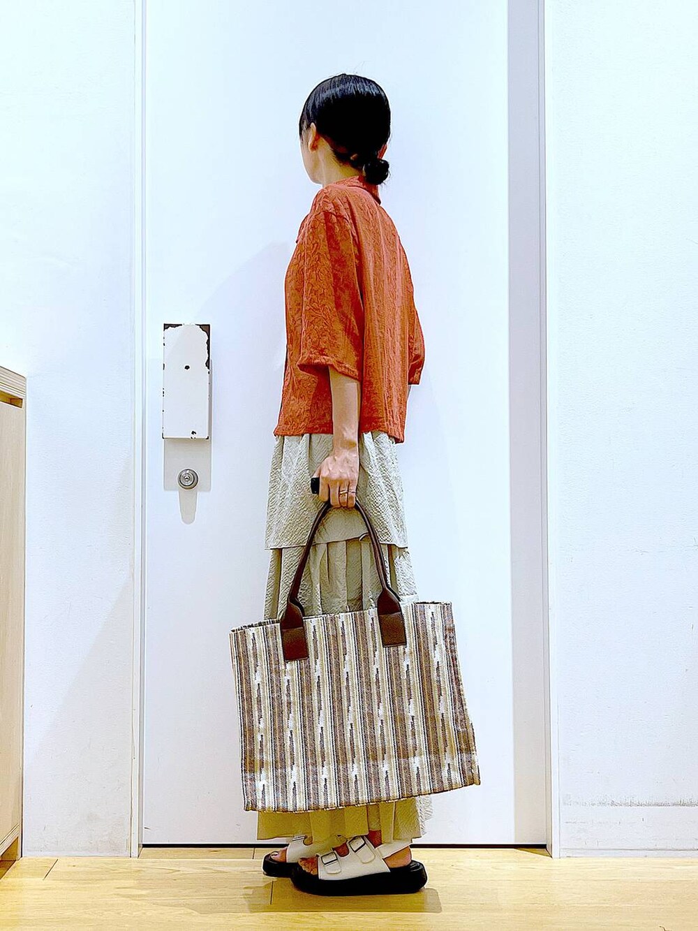 ホワイト系のサンダル、ベージュ系のスカート、レッド系のシャツ/ブラウスを着用したレディースの夏コーディネートの3枚目の写真