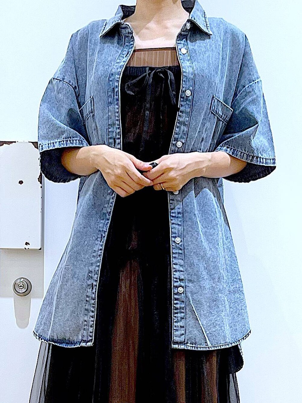 ブラック系のサンダル、ブラウン系のトートバッグ、ブラック系のワンピースを着用したレディースの夏コーディネートの7枚目の写真