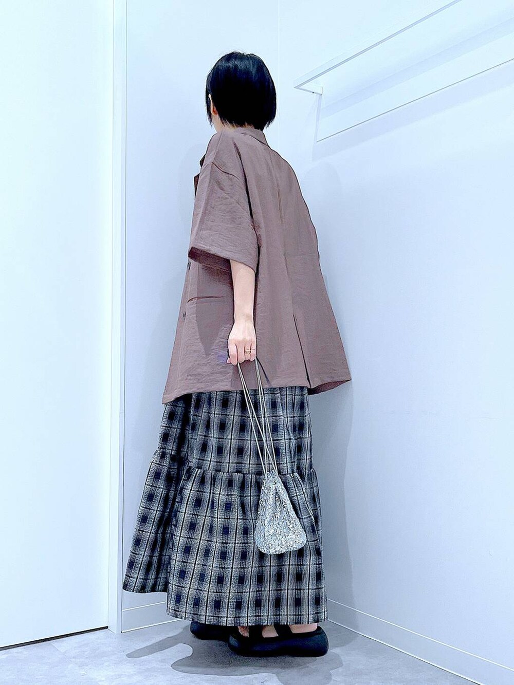 ブラック系のサンダル、シルバー系のショルダーバッグ、ブラウン系のテーラードジャケットを着用したレディースの夏コーディネートの3枚目の写真