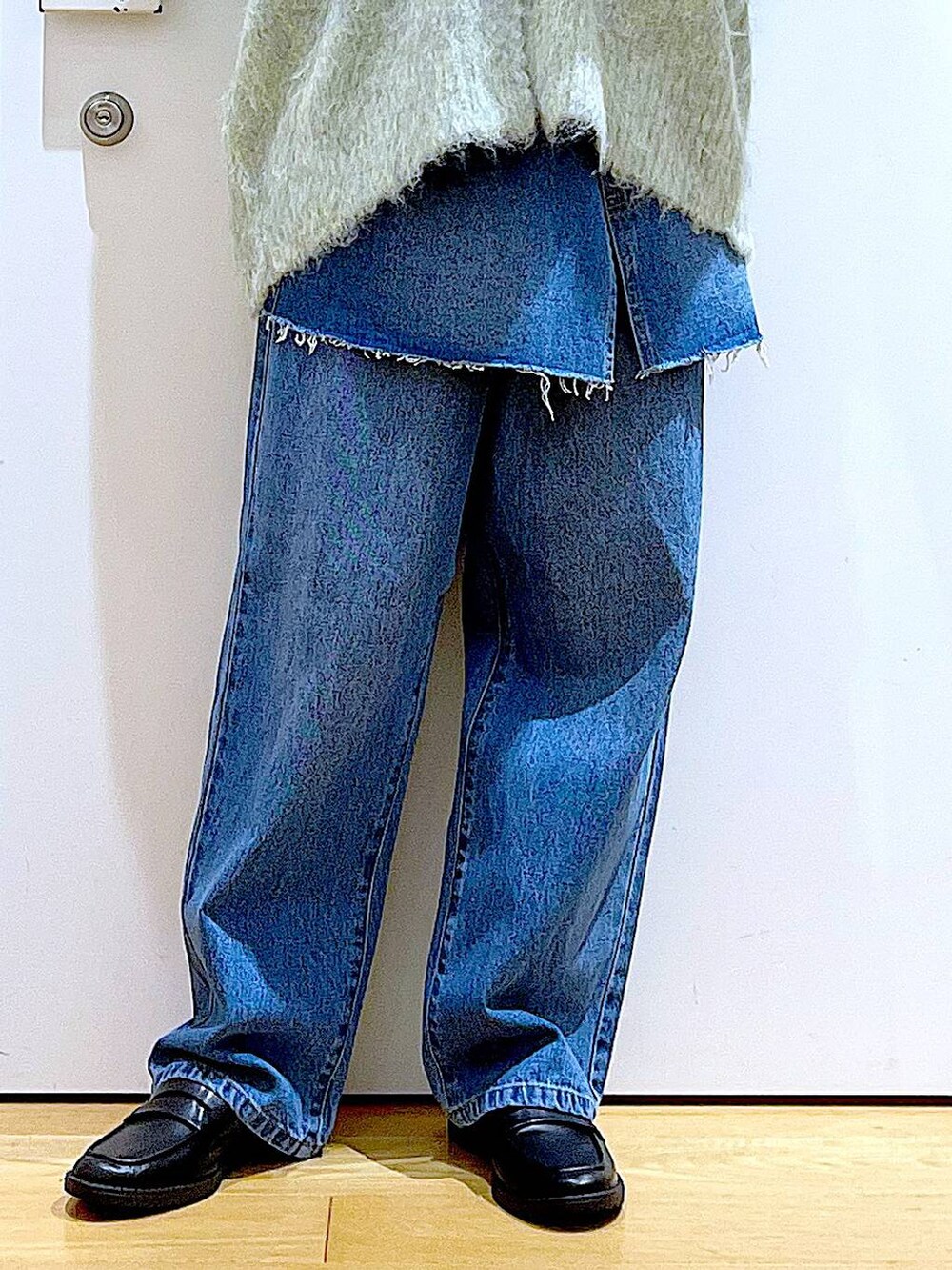 グリーン系のカーディガン/ボレロ、ブラック系のローファー、ブルー系のデニムパンツを着用したレディースの秋コーディネートの8枚目の写真