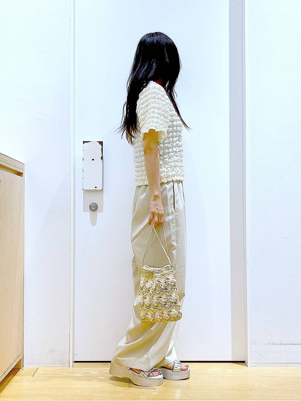 シルバー系のサンダル、ベージュ系のショルダーバッグ、ベージュ系のTシャツ/カットソーを着用したレディースの夏コーディネートの4枚目の写真