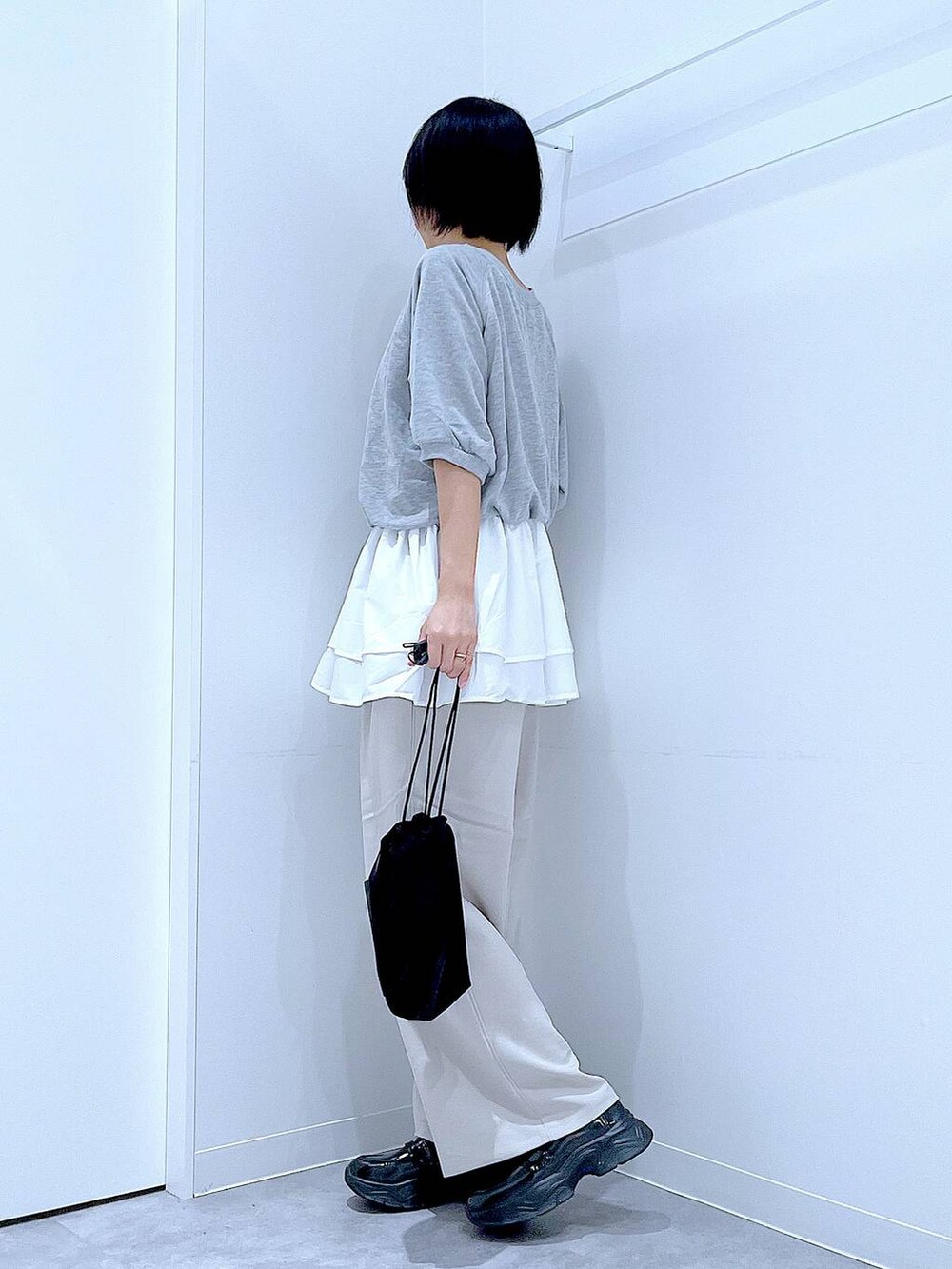 ベージュ系のその他パンツ、ブラック系のローファー、ブラック系のショルダーバッグを着用したレディースの秋コーディネートの3枚目の写真