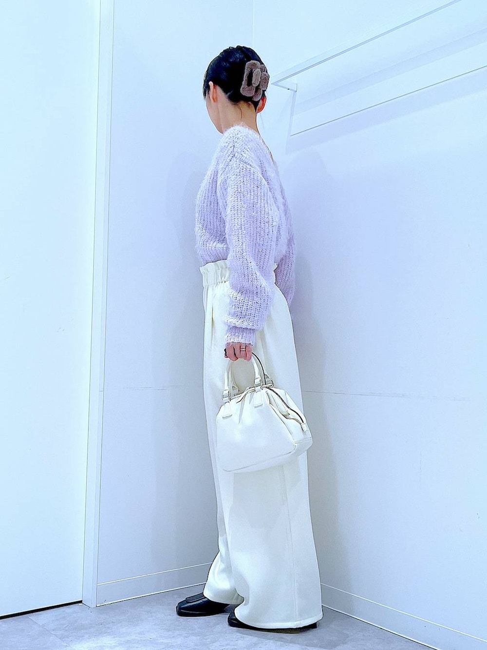 ブラック系のブーツ、ホワイト系のショルダーバッグ、パープル系のニット/セーターを着用したレディースの冬コーディネートの3枚目の写真