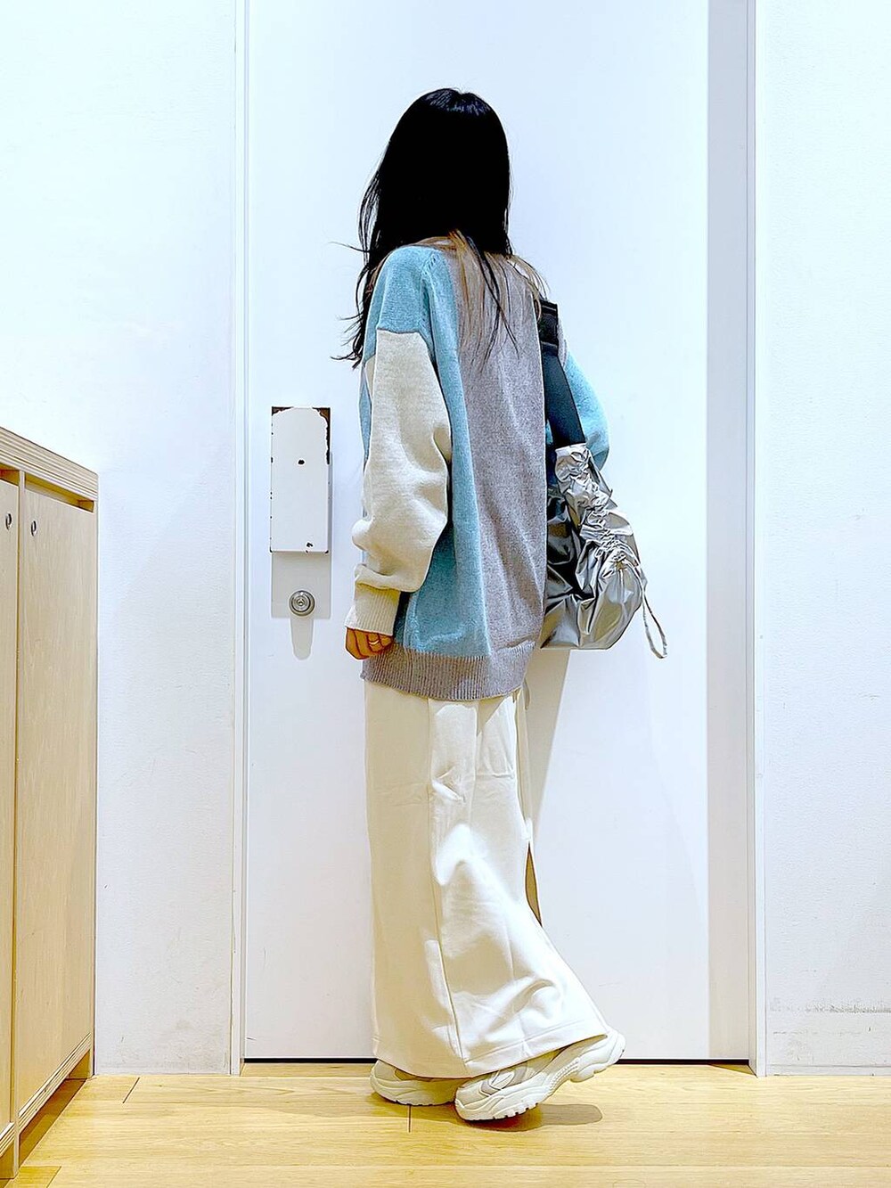 ベージュ系のスニーカー、グレー系のニット/セーター、ベージュ系のスカートを着用したレディースの冬コーディネートの3枚目の写真