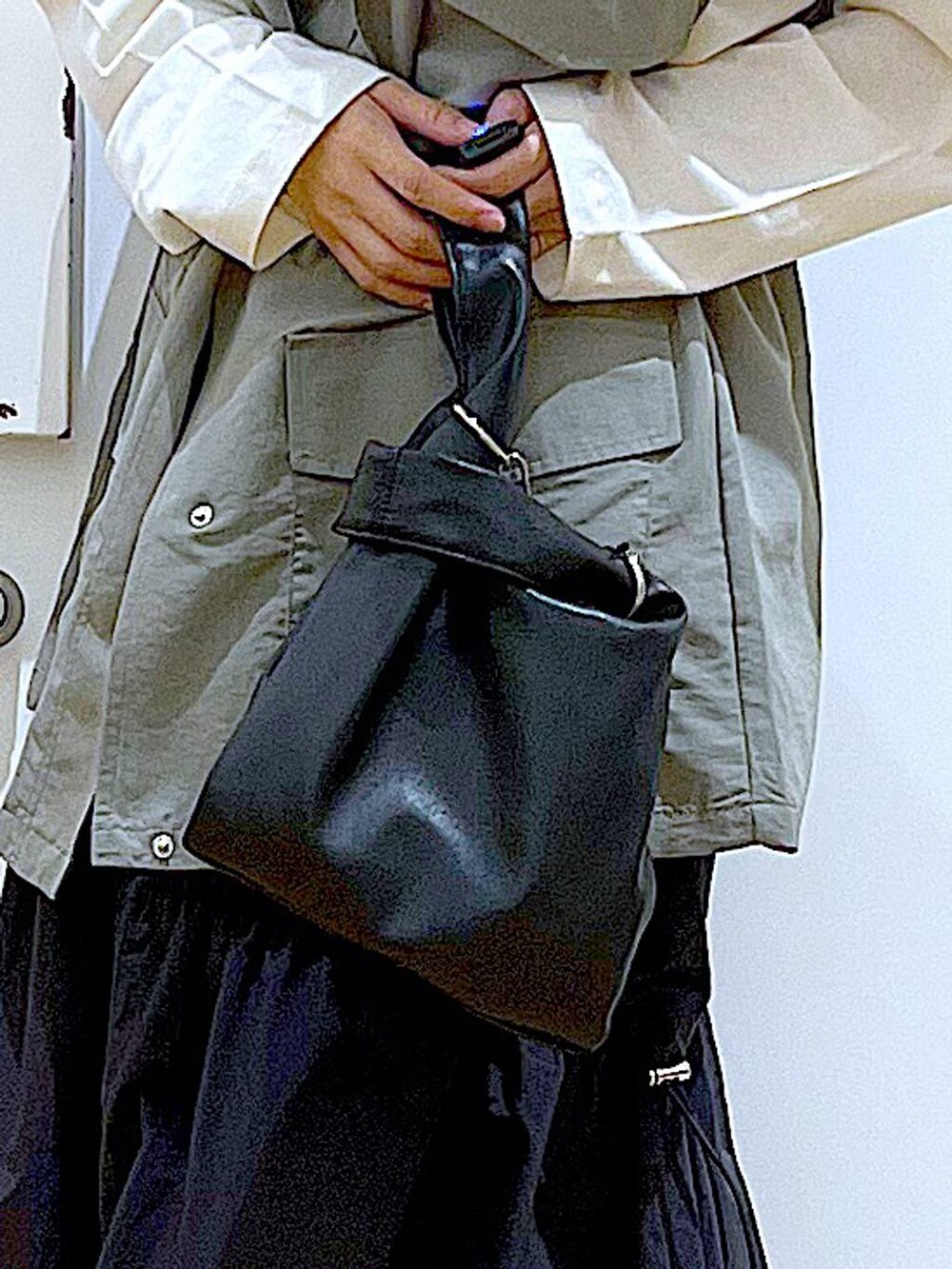 ブラック系のショルダーバッグ、ブラック系のスニーカー、ブラック系のスカートを着用したレディースの春コーディネートの9枚目の写真