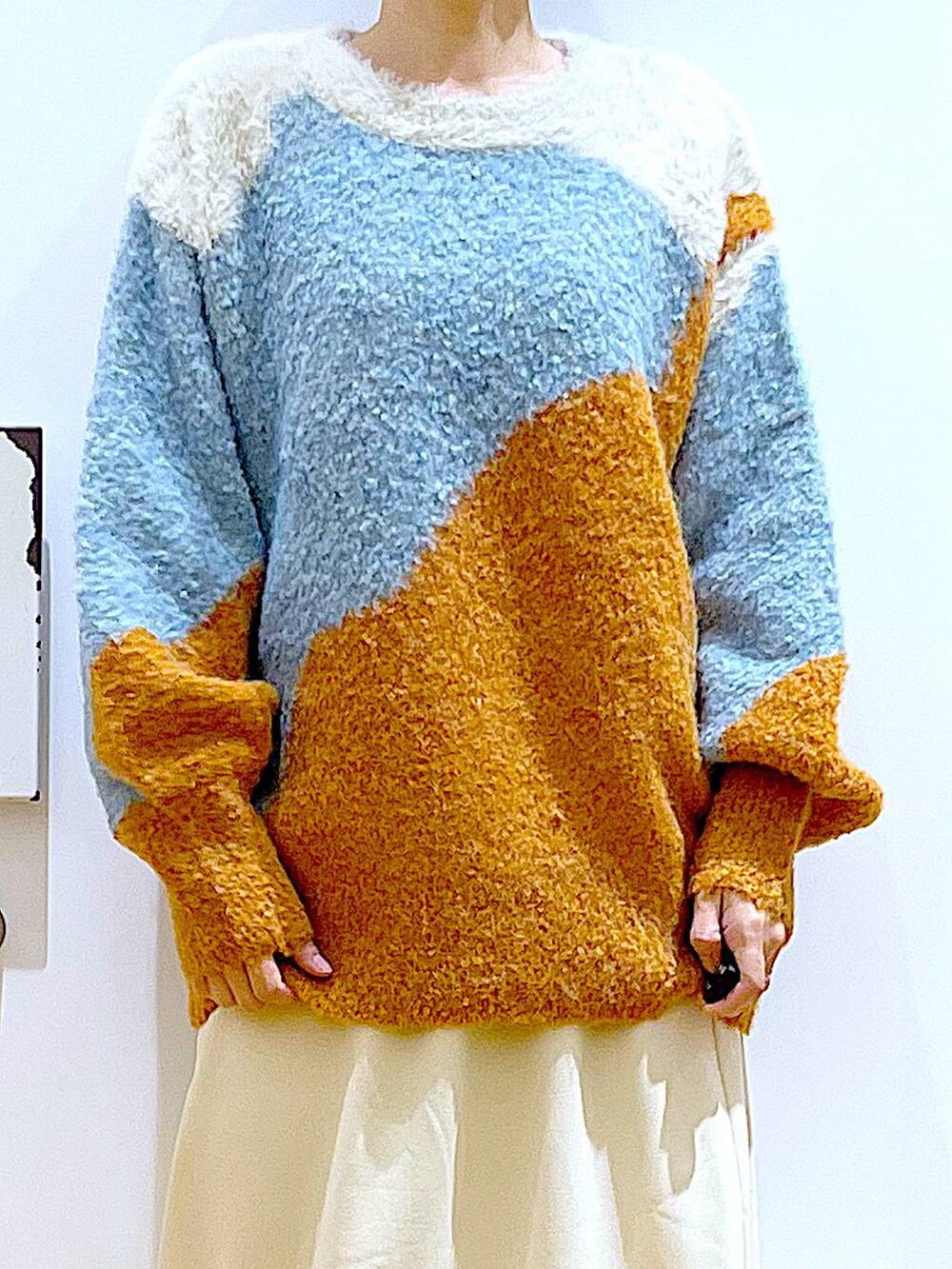 ブラック系のショルダーバッグ、ブラック系のブーツ、オレンジ系のニット/セーターを着用したレディースの冬コーディネートの7枚目の写真