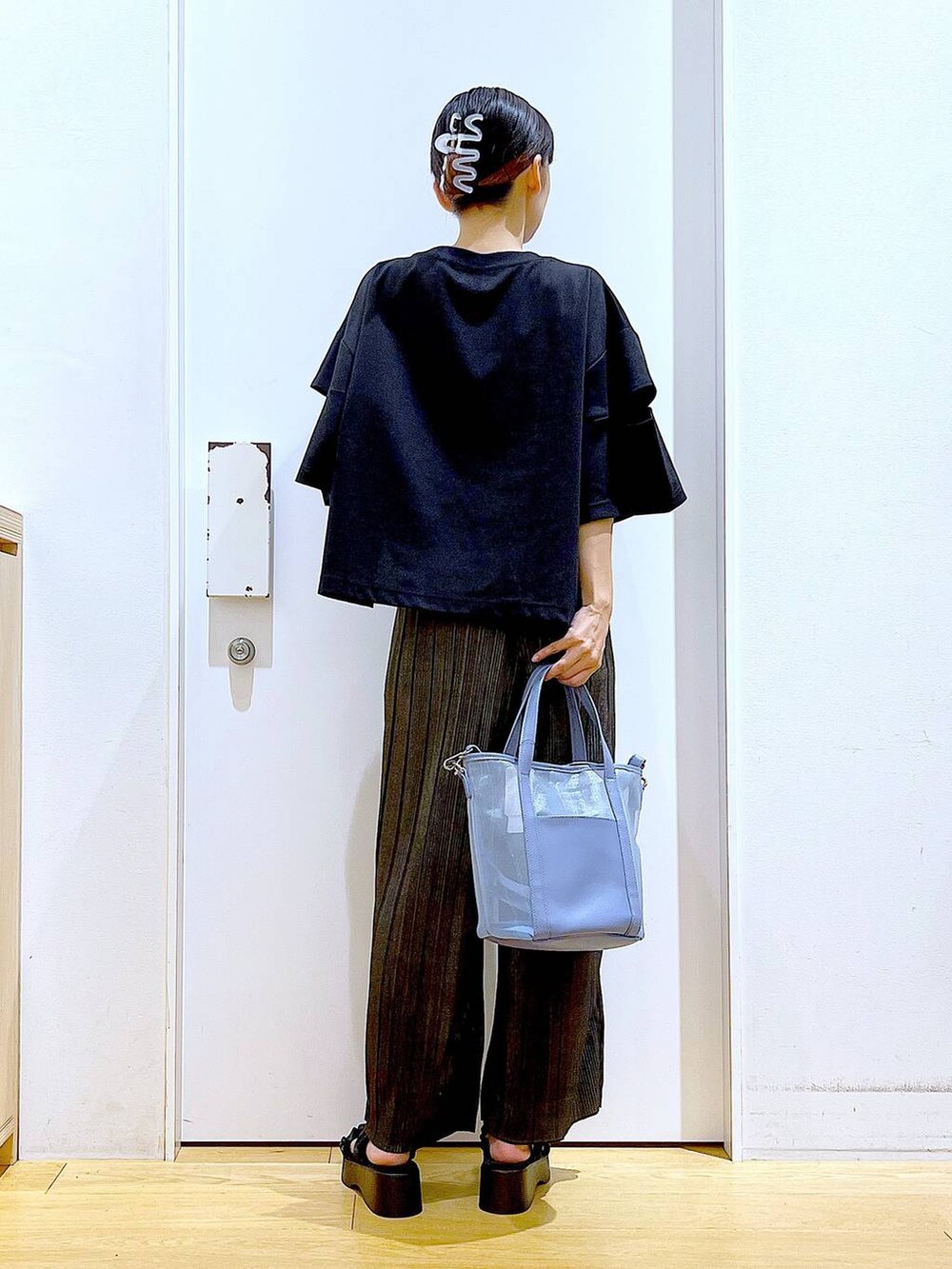 ブラック系のサンダル、ブルー系のトートバッグ、ブラック系のTシャツ/カットソーを着用したレディースの秋コーディネートの5枚目の写真