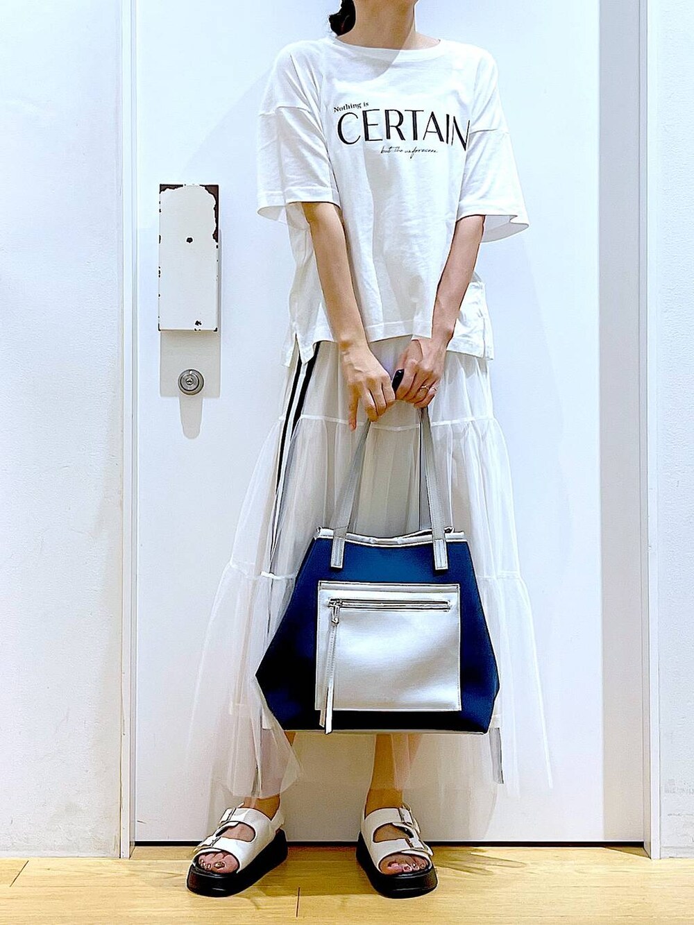 ホワイト系のサンダル、ホワイト系のスカート、ホワイト系のTシャツ/カットソーを着用したレディースの夏コーディネートの6枚目の写真