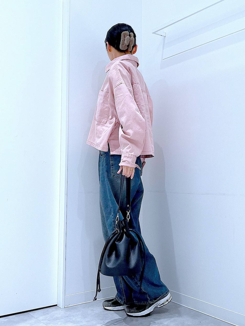 ブルー系のデニムパンツ、ピンク系のシャツ/ブラウス、ブラック系のショルダーバッグを着用したレディースの冬コーディネートの3枚目の写真