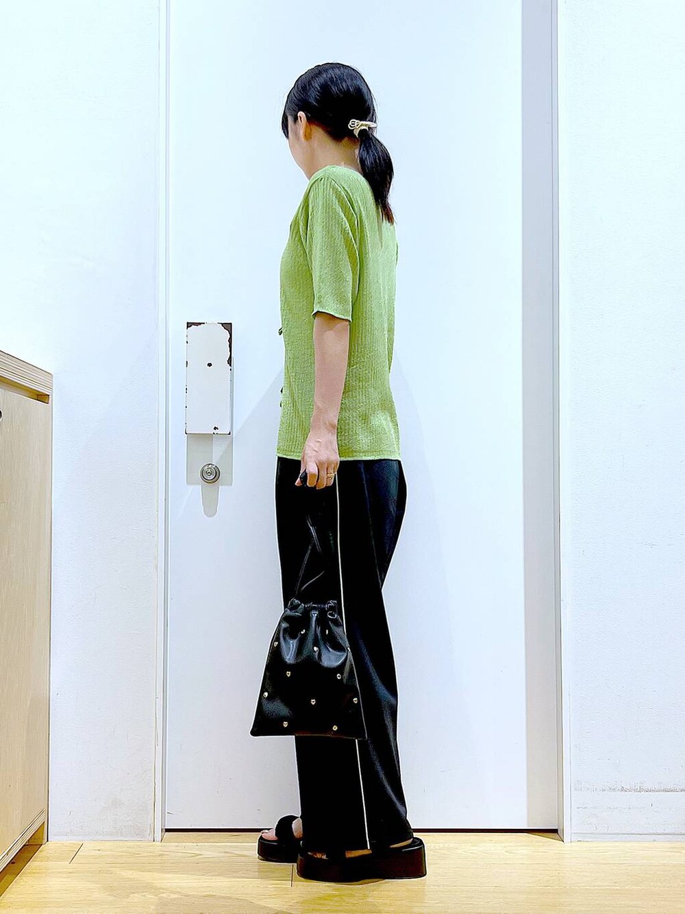 ブラック系のサンダル、ホワイト系のニット/セーター、ブラック系のショルダーバッグを着用したレディースの夏コーディネートの3枚目の写真