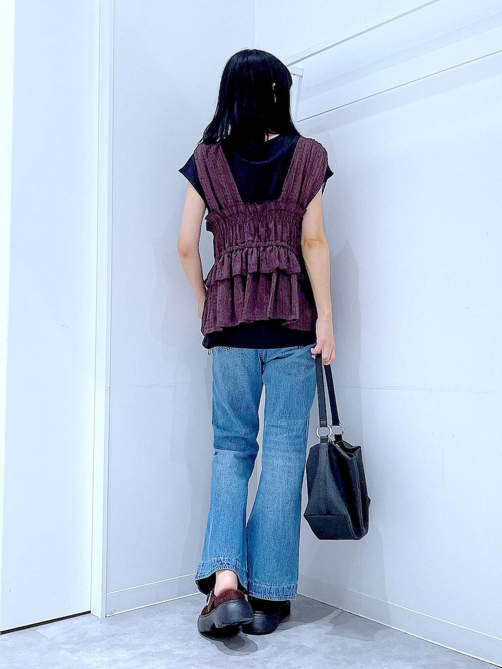 ブルー系のデニムパンツ、ブラウン系のベスト、ブラウン系のその他シューズを着用したレディースの夏コーディネートの5枚目の写真