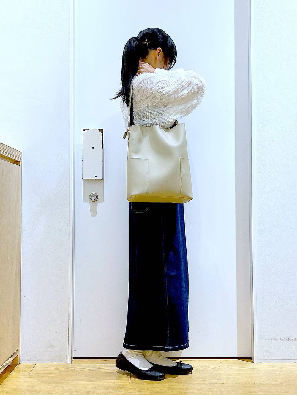 グレー系のショルダーバッグ、ブラック系のバレエシューズ、ブルー系のジャンパースカートを着用したレディースの春コーディネートの4枚目の写真