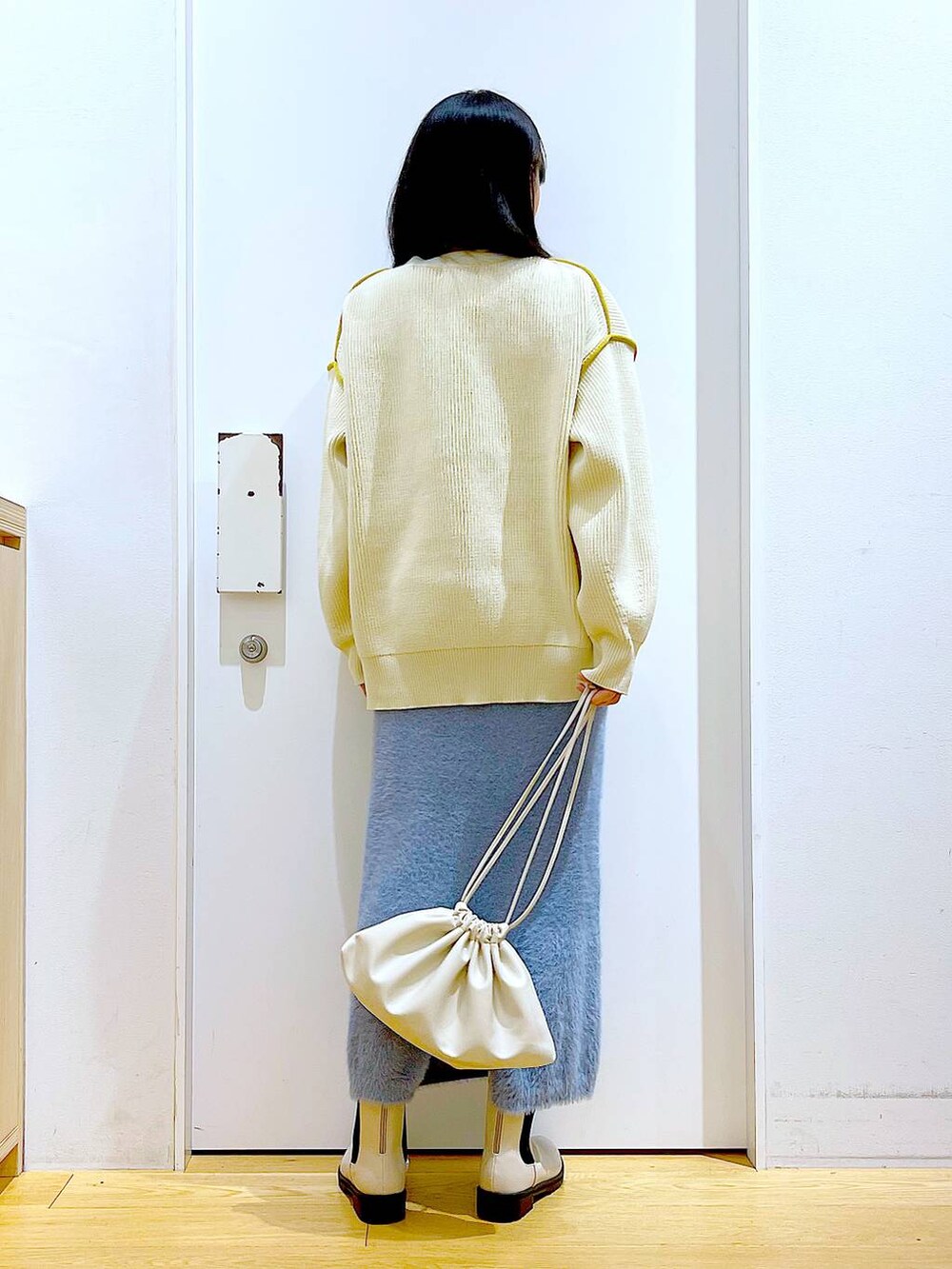 ベージュ系のブーツ、ベージュ系のニット/セーター、ベージュ系のショルダーバッグを着用したレディースの冬コーディネートの5枚目の写真