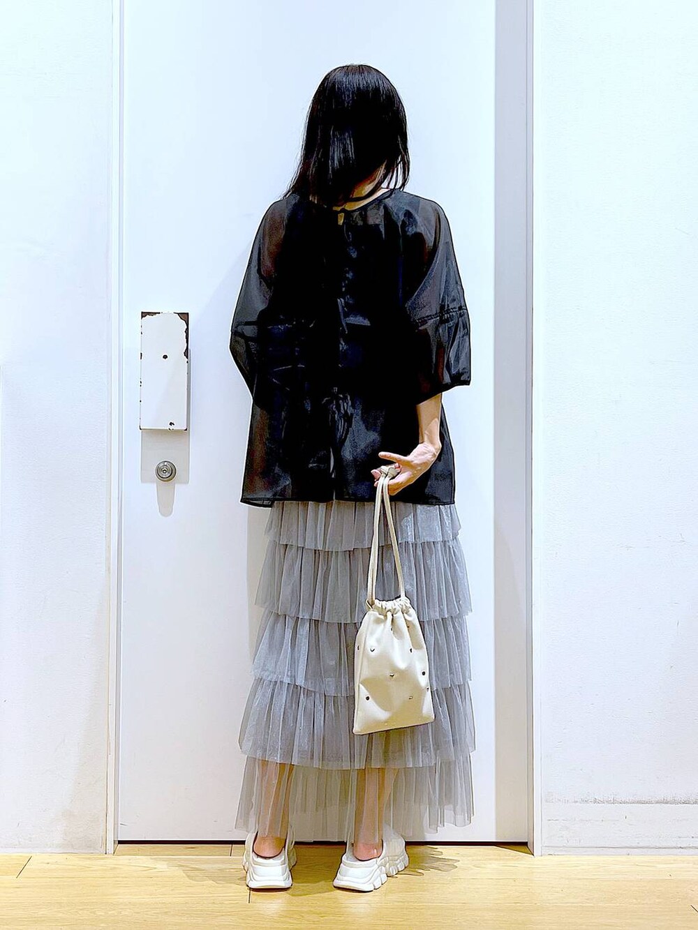 ホワイト系のサンダル、ブラック系のニット/セーター、ホワイト系のショルダーバッグを着用したレディースの夏コーディネートの5枚目の写真