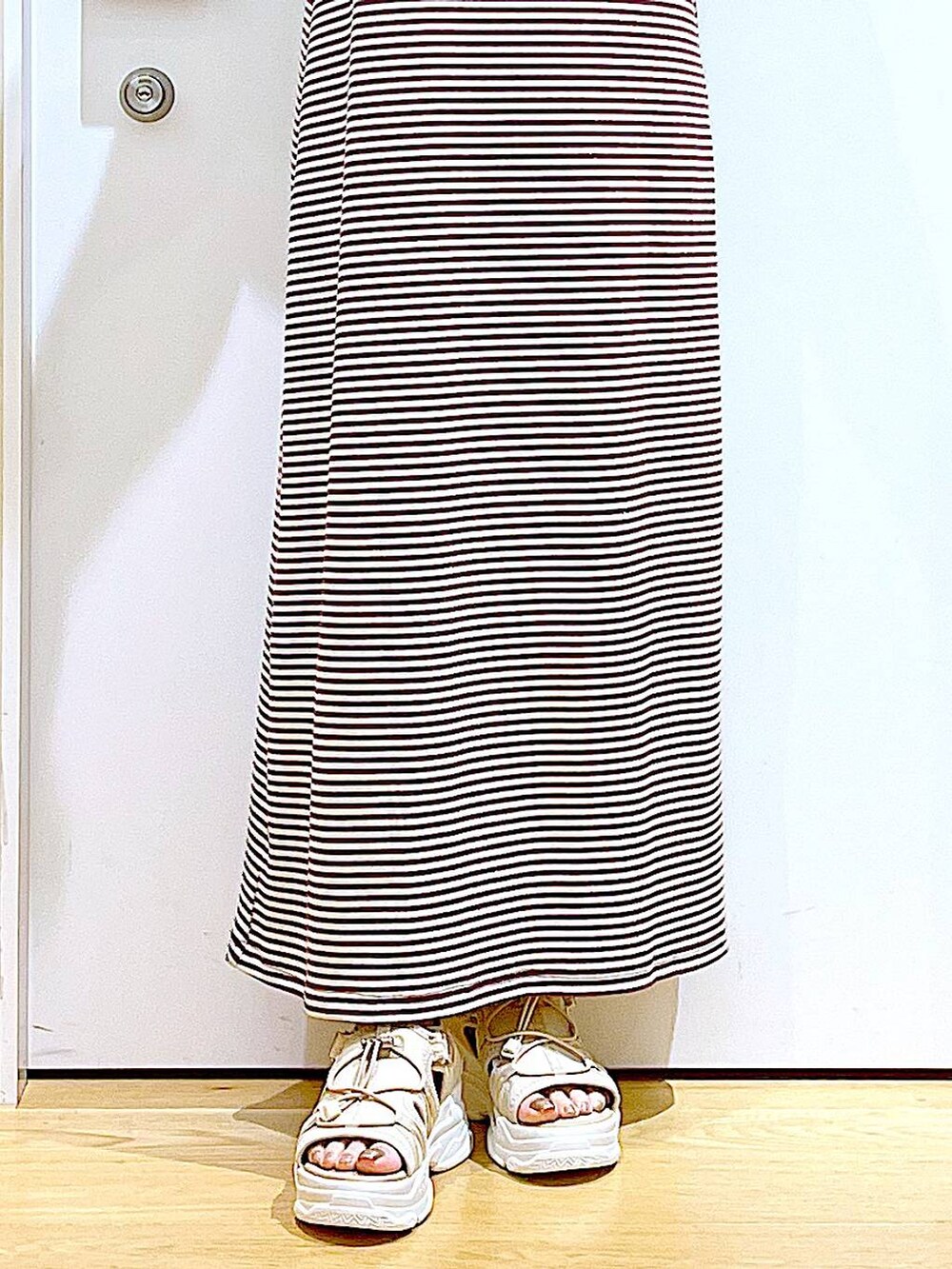 ベージュ系のサンダル、グレー系のトートバッグ、ベージュ系のワンピースを着用したレディースの夏コーディネートの8枚目の写真