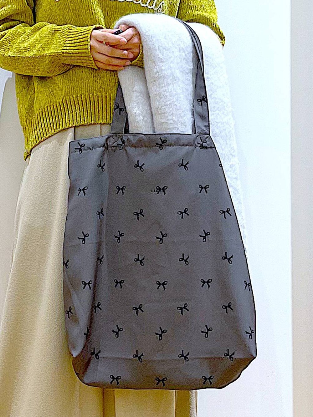 ブラック系のブーツ、その他のトートバッグ、グレー系のスカートを着用したレディースの冬コーディネートの9枚目の写真