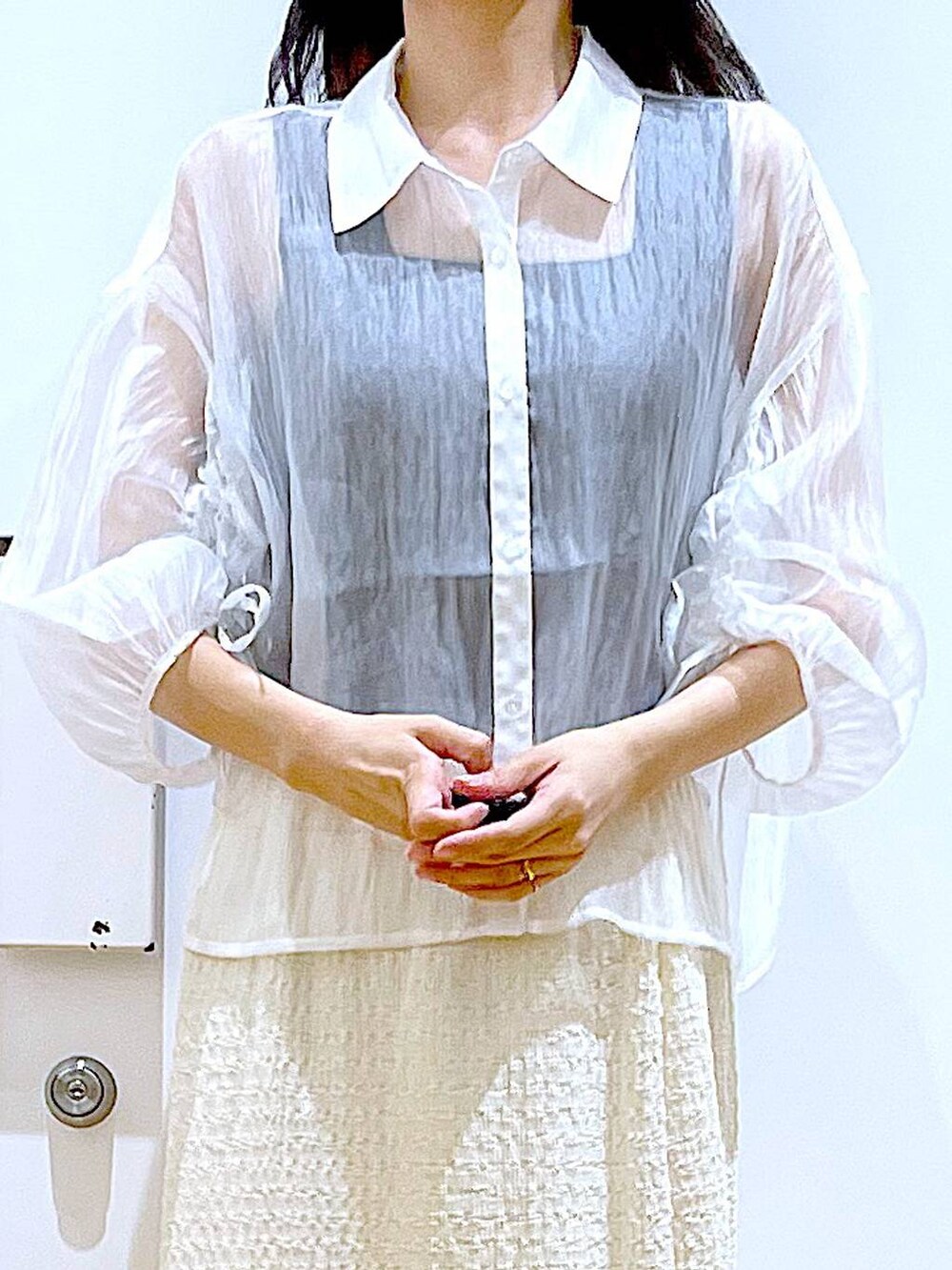 ホワイト系のサンダル、ブラック系のニット/セーター、ブルー系のトートバッグを着用したレディースの夏コーディネートの7枚目の写真