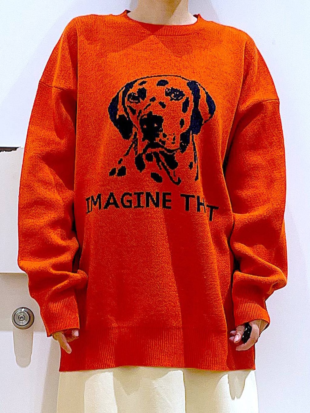 グレー系のショルダーバッグ、オレンジ系のニット/セーター、ブラック系のブーツを着用したレディースの冬コーディネートの7枚目の写真