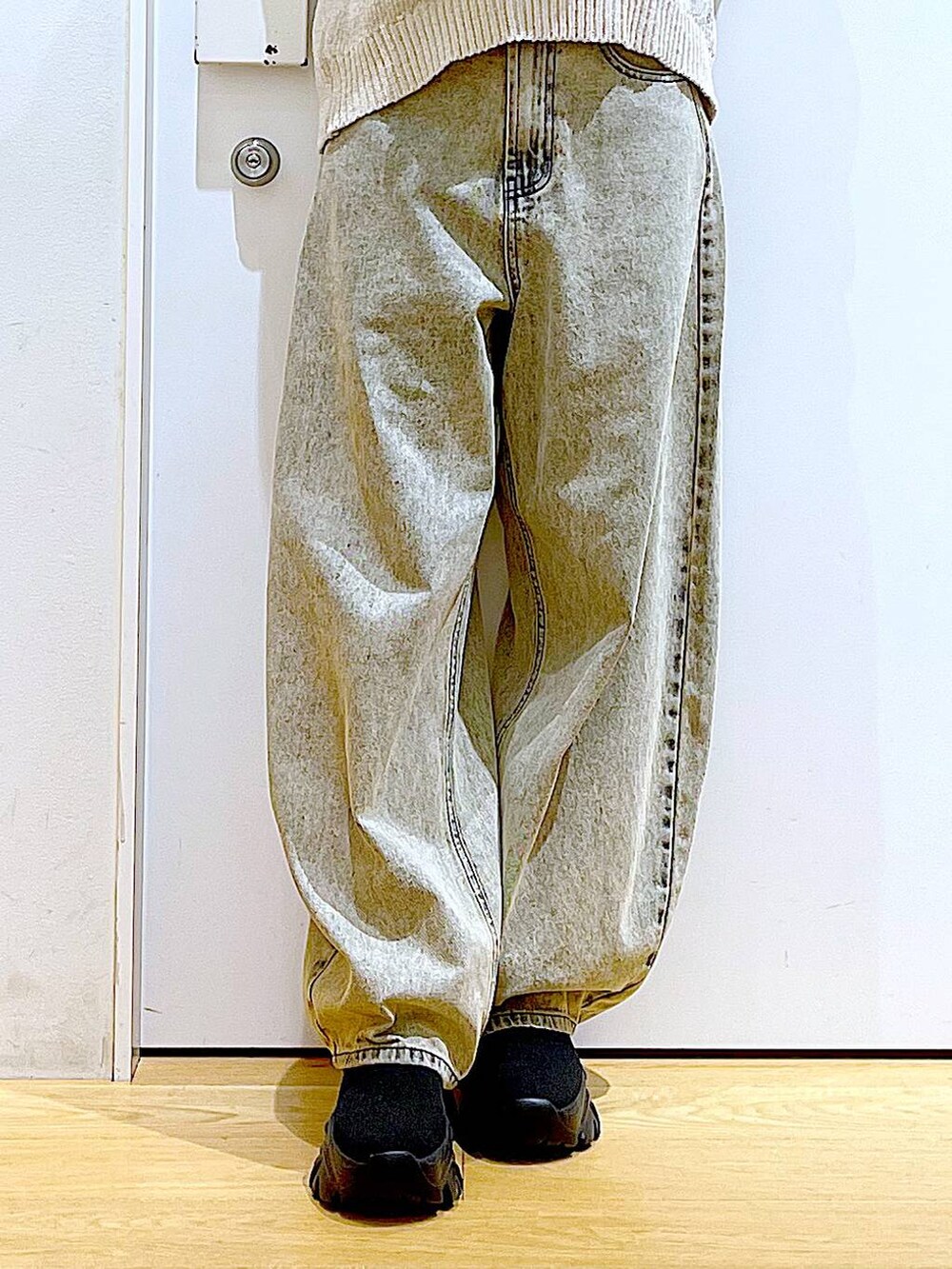 ホワイト系のショルダーバッグ、ブラック系のブーツ、ベージュ系のデニムパンツを着用したレディースの冬コーディネートの8枚目の写真
