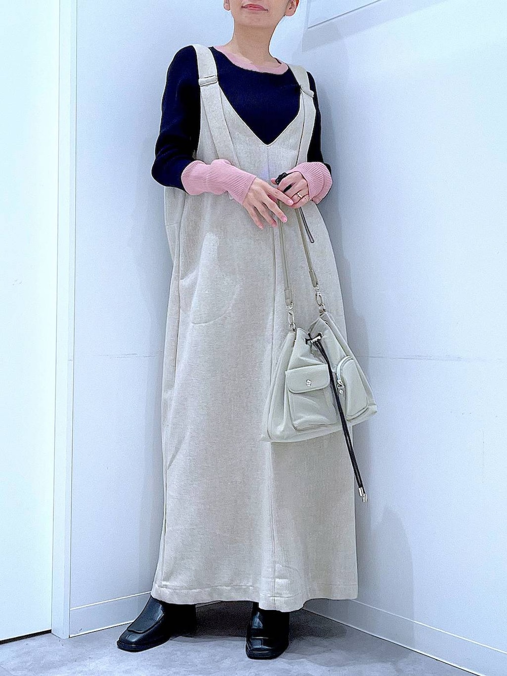 ブラック系のブーツ、ベージュ系のジャンパースカート、ブルー系のニット/セーターを着用したレディースの冬コーディネートの6枚目の写真