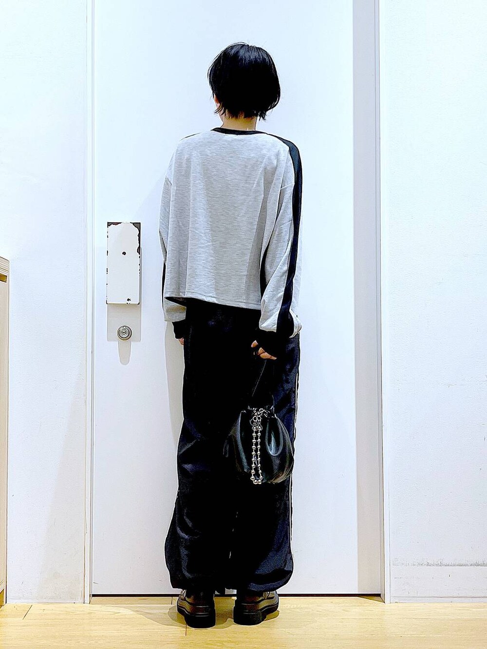 ブラック系のショルダーバッグ、ブラック系のブーツ、グレー系のTシャツ/カットソーを着用したレディースの秋コーディネートの5枚目の写真