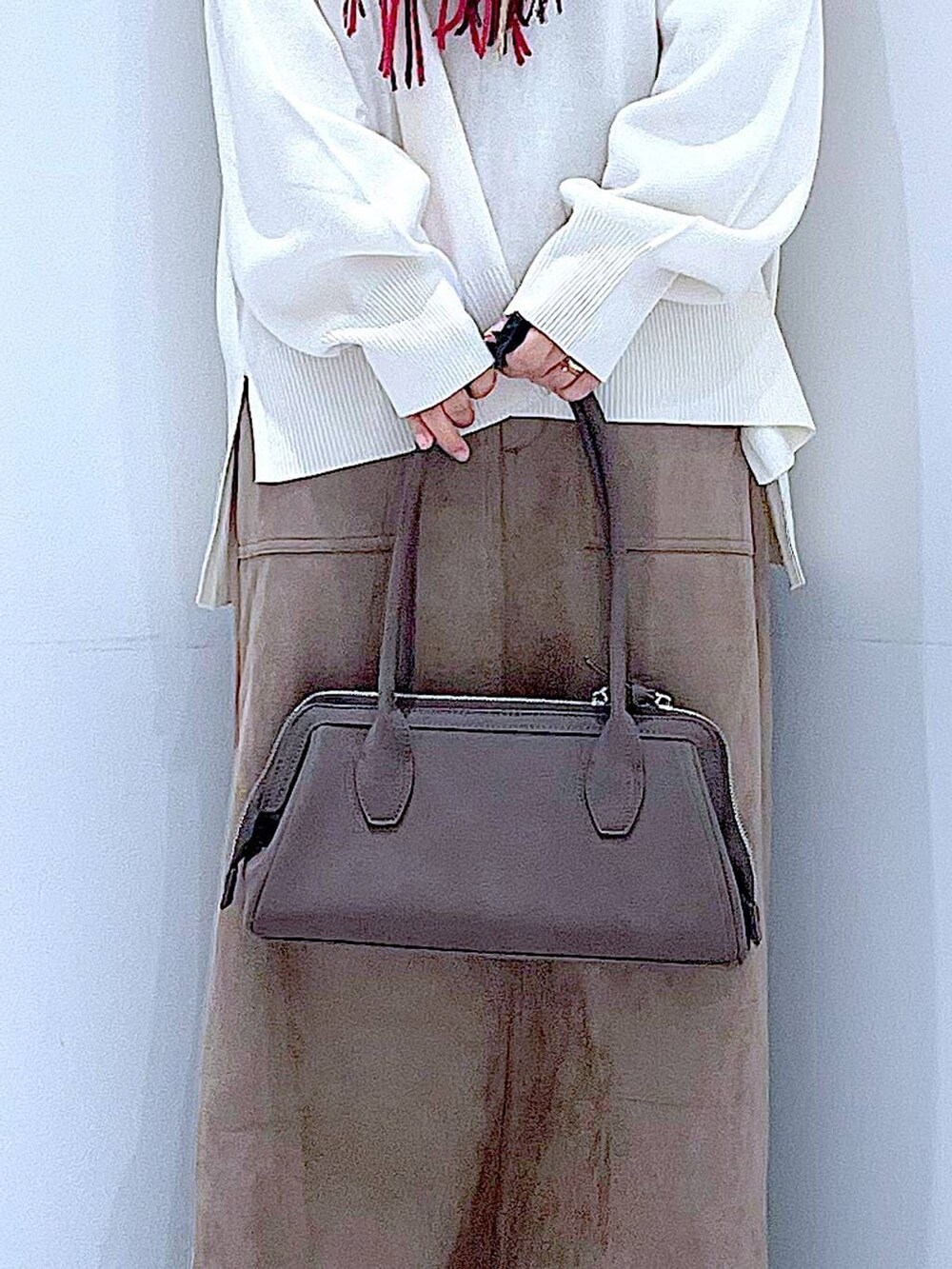 ブラック系のブーツ、ベージュ系のニット/セーター、ブラウン系のスカートを着用したレディースの秋コーディネートの9枚目の写真