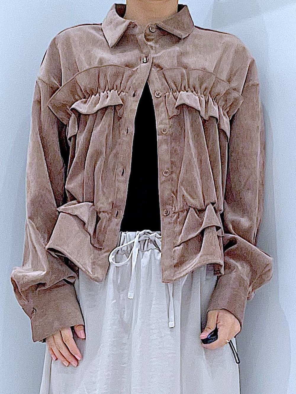 ベージュ系のスカート、ホワイト系のショルダーバッグ、ブラック系のブーツを着用したレディースの秋コーディネートの7枚目の写真