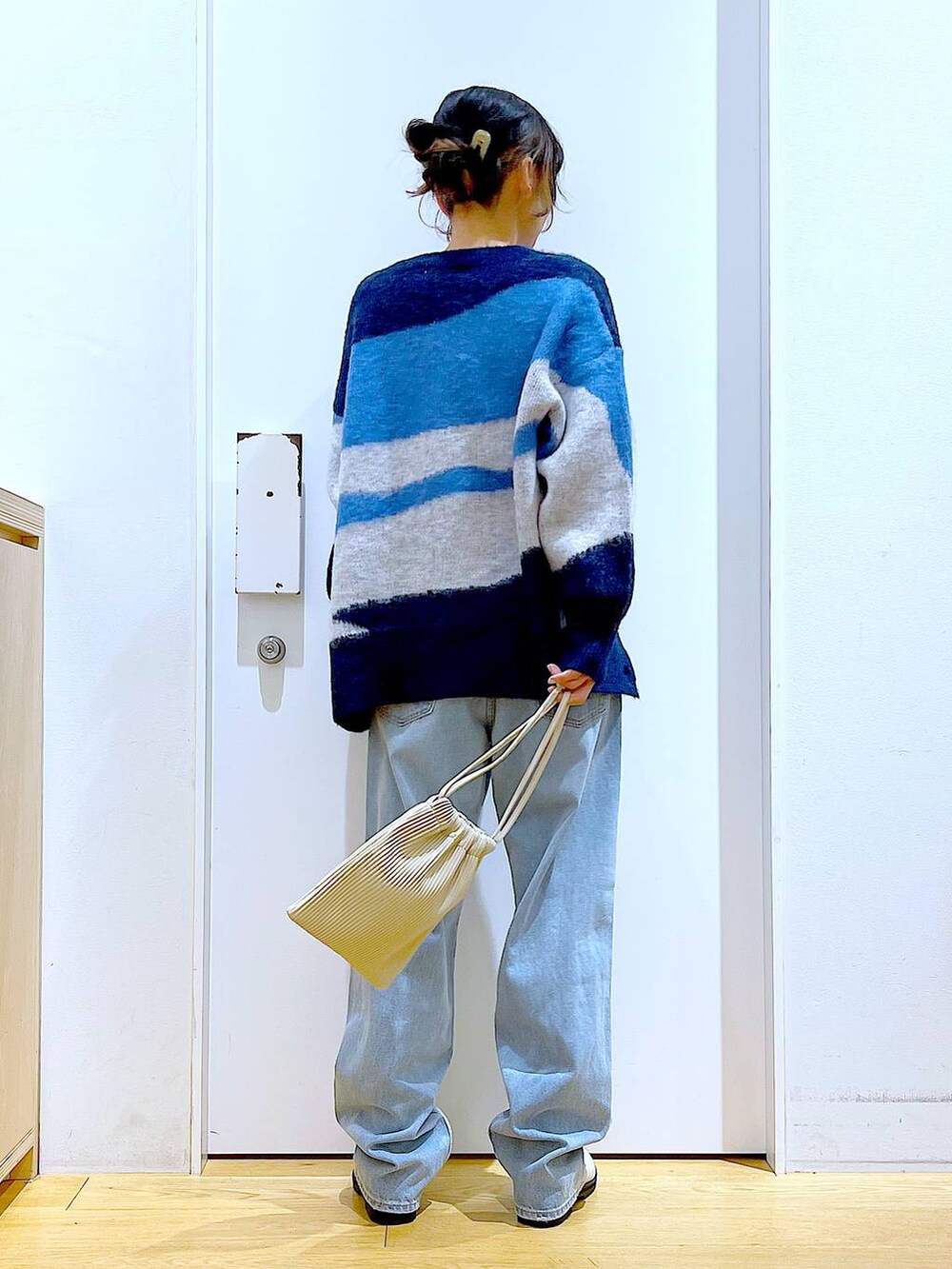 ベージュ系のショルダーバッグ、ベージュ系のブーツ、ブラック系のニット/セーターを着用したレディースの冬コーディネートの5枚目の写真