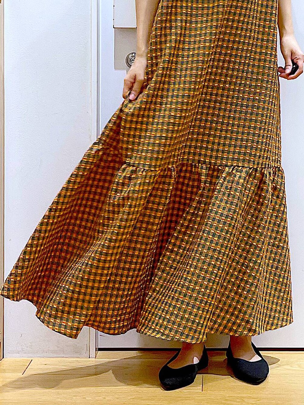 オレンジ系のワンピース、ブラック系のバックパック/リュック、ブラック系のパンプスを着用したレディースの春コーディネートの8枚目の写真